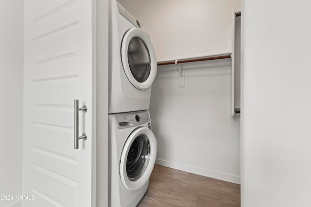 washroom featuring dark wood-type flooring and stacked washer and dryer