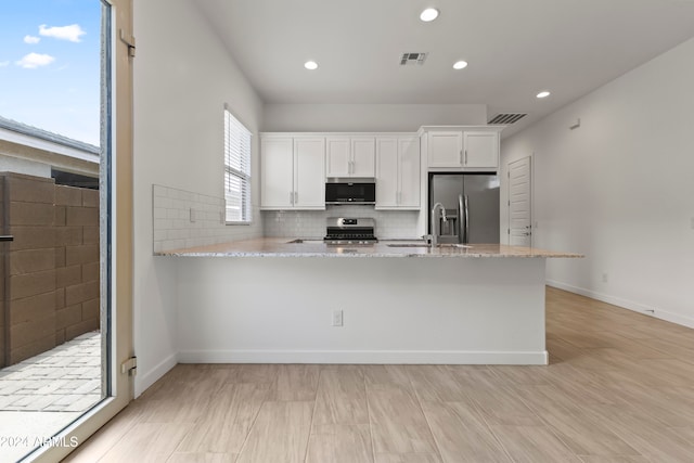 kitchen featuring white cabinets, sink, light stone counters, and appliances with stainless steel finishes