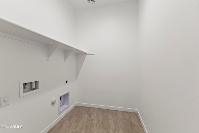 clothes washing area featuring light wood-type flooring, hookup for a washing machine, hookup for a gas dryer, and hookup for an electric dryer