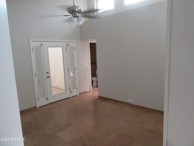 empty room featuring a high ceiling and ceiling fan