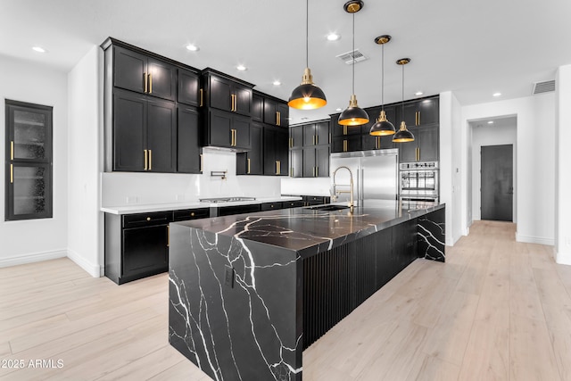 kitchen with appliances with stainless steel finishes, visible vents, and light wood-style floors