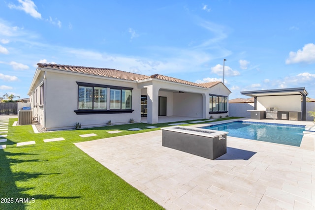 back of house with a fire pit, a patio area, ceiling fan, and exterior kitchen