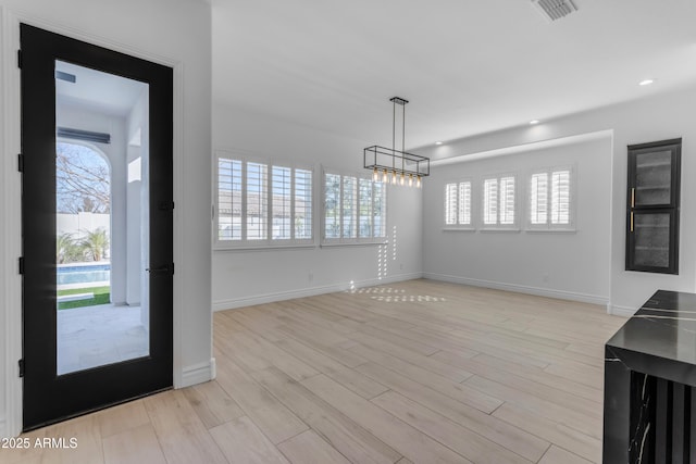 unfurnished dining area featuring light wood-style floors, visible vents, and plenty of natural light