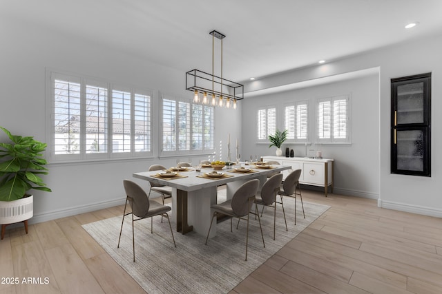 dining space with baseboards, light wood finished floors, and recessed lighting