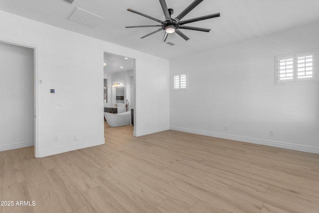 empty room with a ceiling fan, light wood-type flooring, and a healthy amount of sunlight