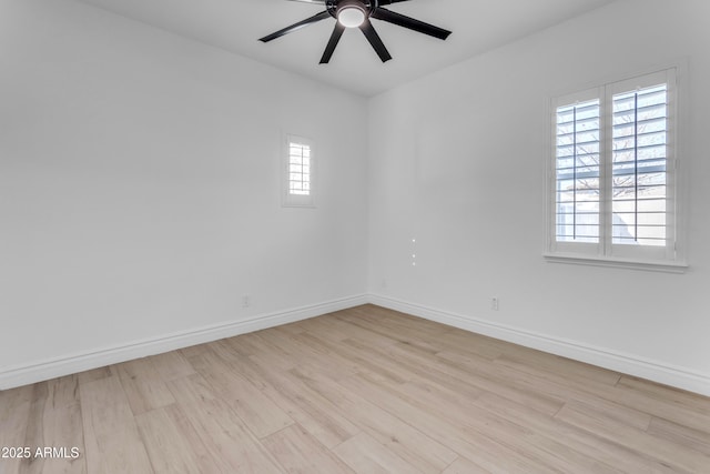 empty room featuring ceiling fan, light wood finished floors, and baseboards