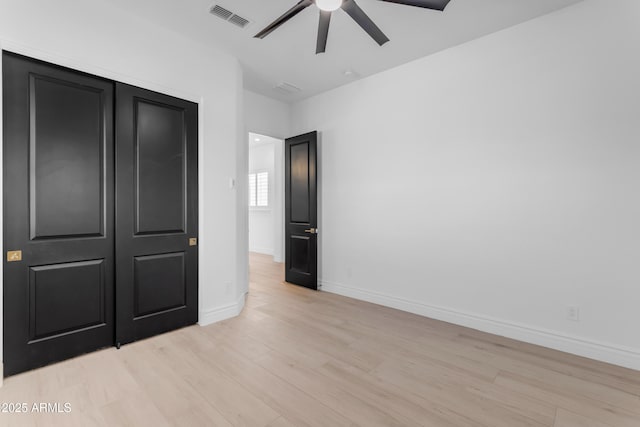 unfurnished bedroom with a ceiling fan, light wood-type flooring, visible vents, and baseboards