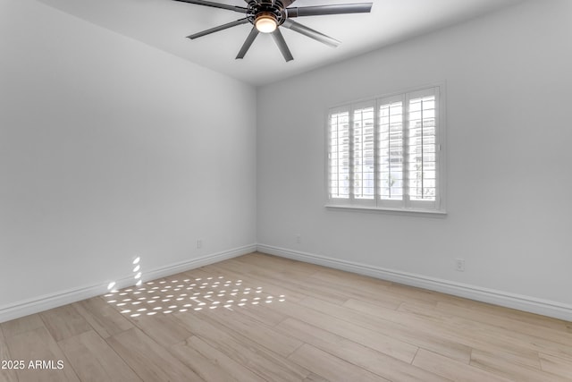 empty room with ceiling fan, baseboards, and wood finished floors