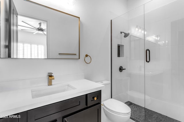 bathroom with toilet, a shower stall, ceiling fan, and vanity