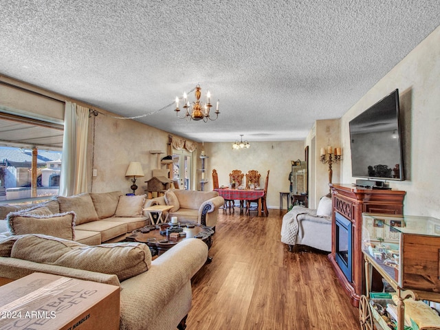 living room featuring hardwood / wood-style floors, a textured ceiling, and a notable chandelier