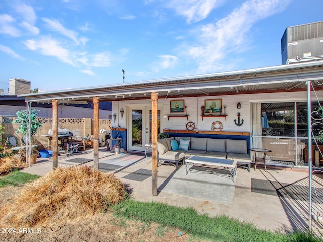 back of house with an outdoor living space, a patio, and central air condition unit