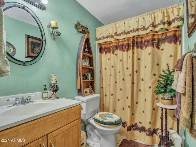 bathroom featuring a textured ceiling, vanity, and toilet