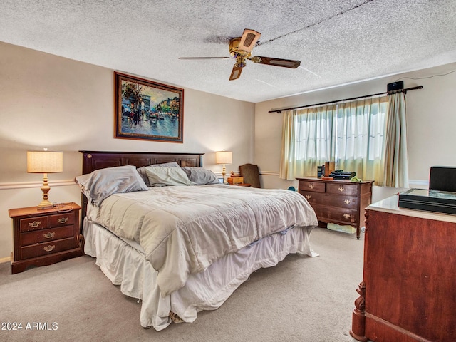 bedroom with ceiling fan, a textured ceiling, and light carpet