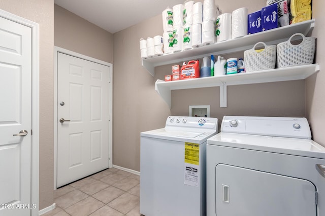 laundry area with laundry area, independent washer and dryer, baseboards, and light tile patterned floors