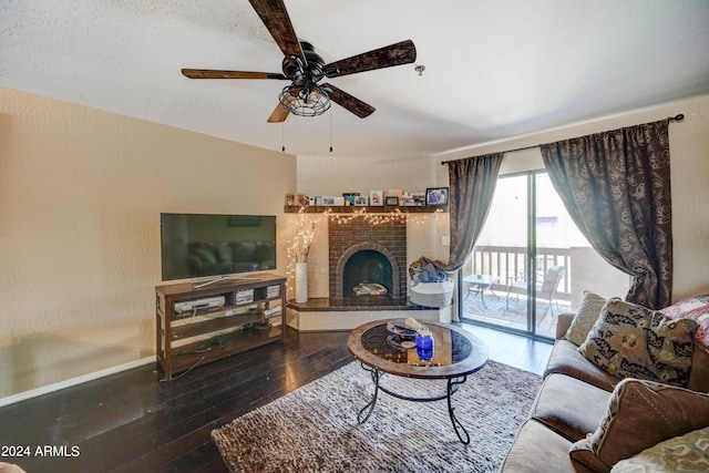 living room with ceiling fan, wood-type flooring, and a brick fireplace