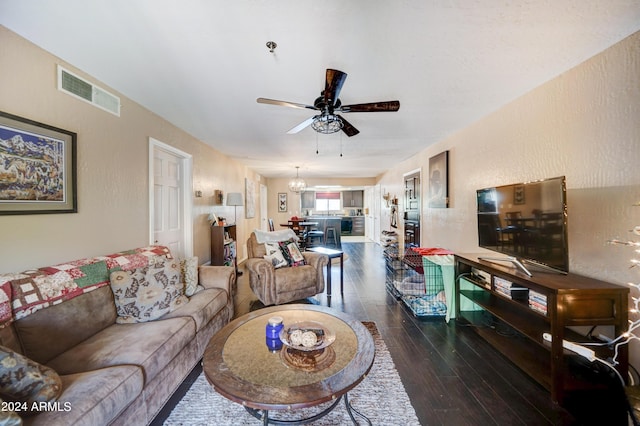 living room featuring dark wood-type flooring and ceiling fan with notable chandelier