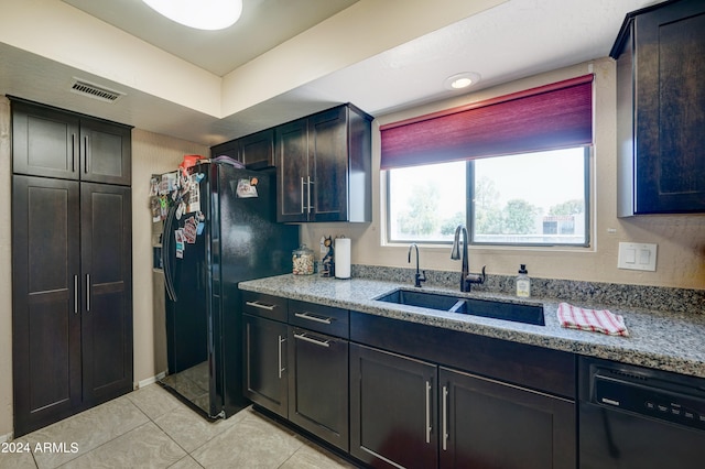 kitchen with sink, light stone countertops, black appliances, and light tile patterned floors