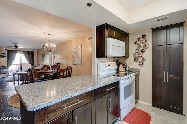 kitchen with ceiling fan with notable chandelier, pendant lighting, light stone countertops, dark brown cabinets, and white appliances