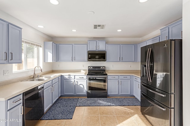 kitchen featuring appliances with stainless steel finishes, light tile patterned floors, and sink