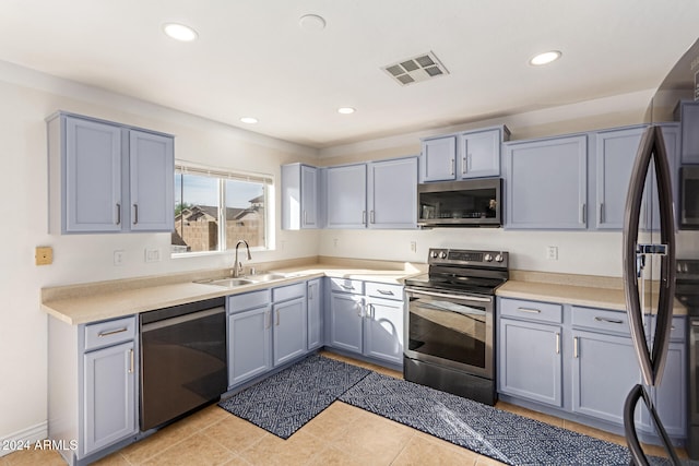 kitchen featuring sink, light tile patterned floors, and stainless steel appliances