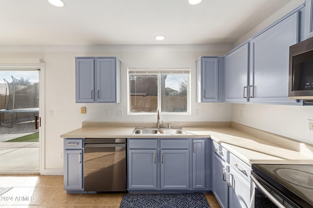 kitchen with appliances with stainless steel finishes, light tile patterned floors, and sink