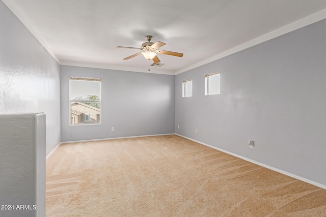 carpeted empty room with plenty of natural light, ornamental molding, and ceiling fan