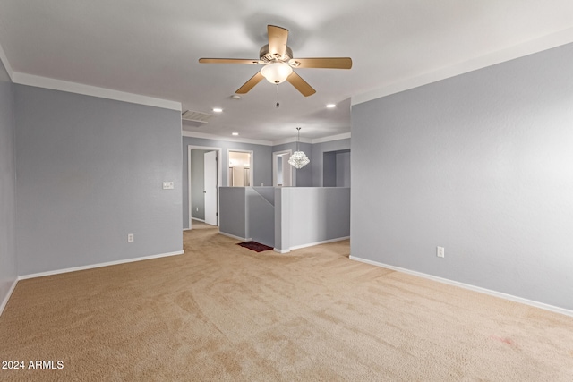 unfurnished living room featuring light colored carpet, ceiling fan with notable chandelier, and ornamental molding