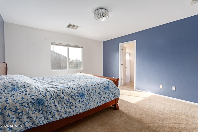 bedroom featuring light carpet and connected bathroom