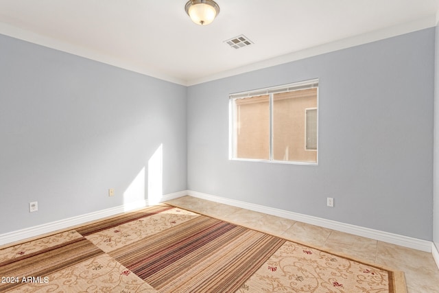 spare room with light tile patterned floors and ornamental molding