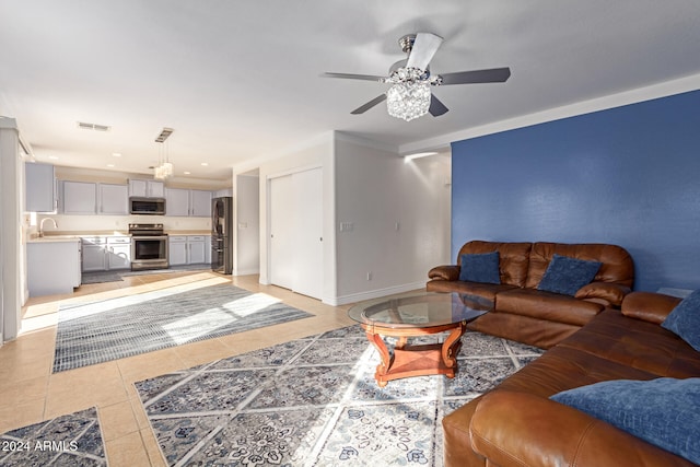 tiled living room with ceiling fan and sink