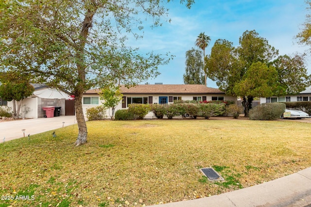 ranch-style house with a front yard and fence