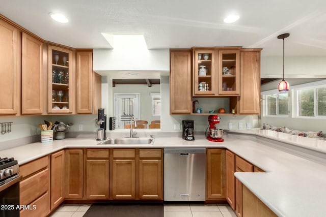 kitchen featuring light tile patterned floors, a sink, light countertops, appliances with stainless steel finishes, and hanging light fixtures