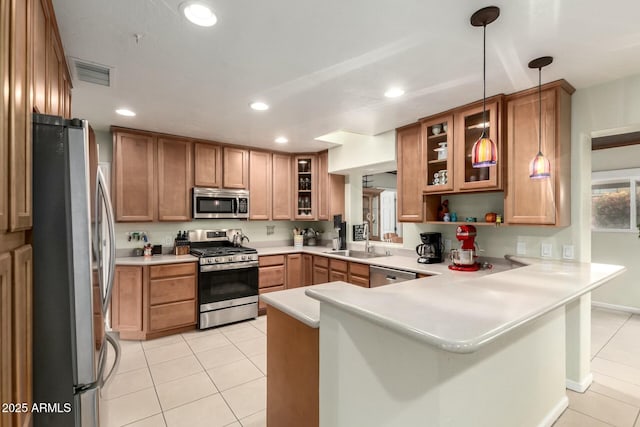 kitchen with light tile patterned floors, visible vents, appliances with stainless steel finishes, a peninsula, and a sink