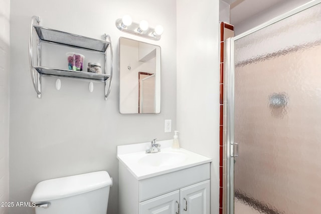 bathroom featuring toilet, a stall shower, and vanity