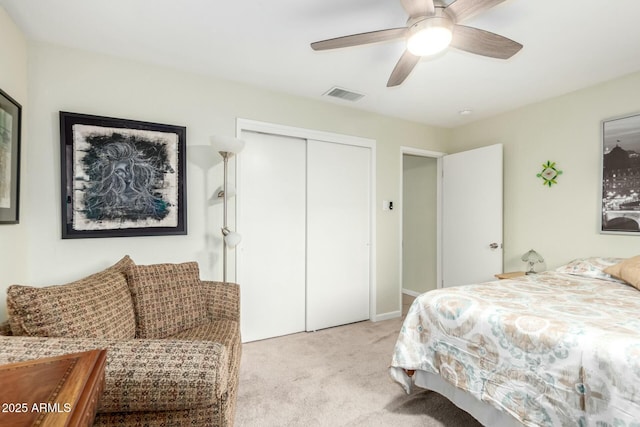 carpeted bedroom with a closet, visible vents, and a ceiling fan