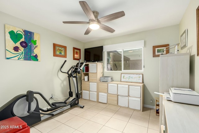 exercise room featuring light tile patterned floors, baseboards, and a ceiling fan