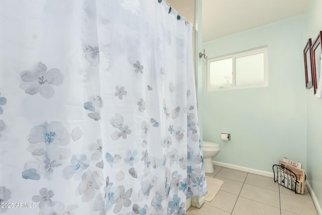 bathroom featuring toilet, a shower with curtain, baseboards, and tile patterned floors