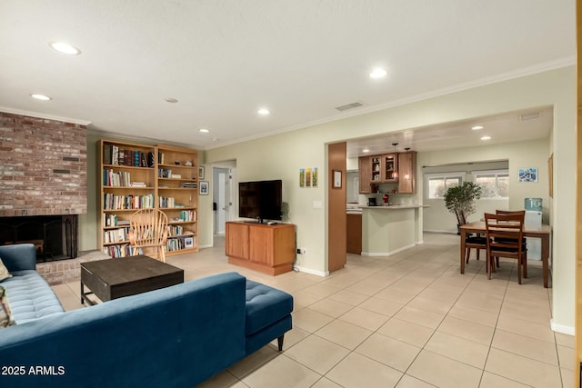 living area featuring crown molding, a fireplace, visible vents, light tile patterned flooring, and baseboards