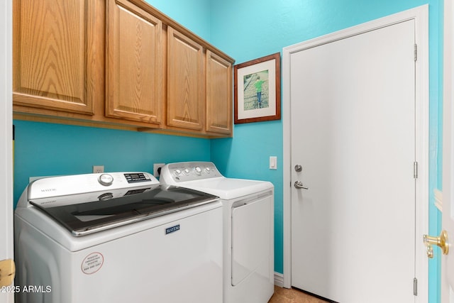 washroom with cabinets and washer and clothes dryer