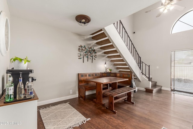 dining room with ceiling fan and dark wood-type flooring