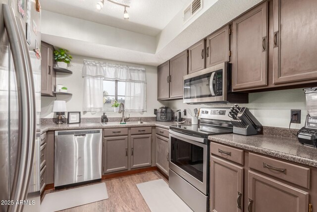 kitchen with sink, light hardwood / wood-style flooring, and appliances with stainless steel finishes