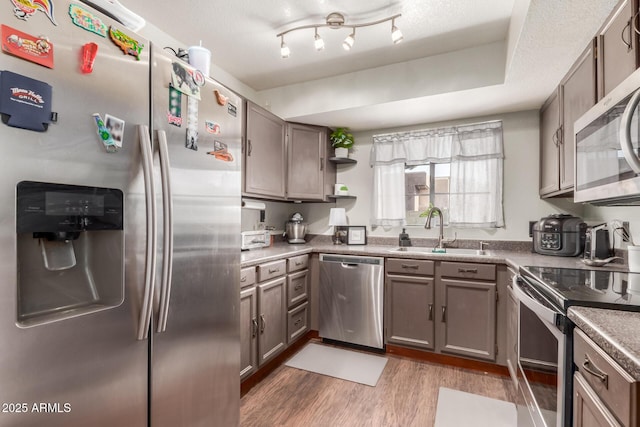 kitchen featuring sink, a textured ceiling, dark hardwood / wood-style floors, and stainless steel appliances