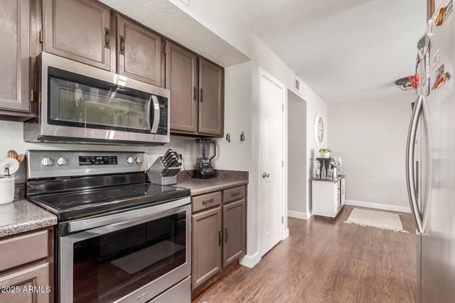 kitchen featuring stainless steel appliances and dark hardwood / wood-style flooring