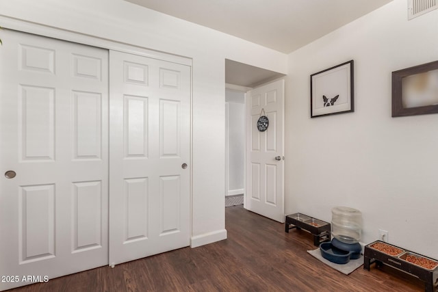 unfurnished bedroom with a closet and dark hardwood / wood-style flooring