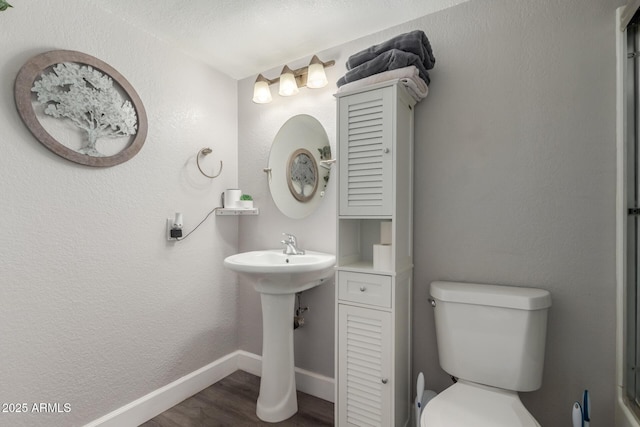 bathroom featuring sink, toilet, a textured ceiling, and hardwood / wood-style flooring