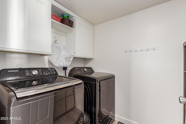 clothes washing area featuring cabinets and washing machine and dryer