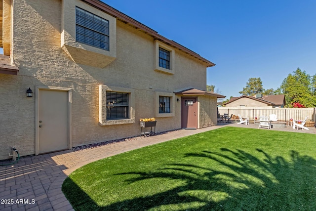 rear view of property with a lawn and a patio