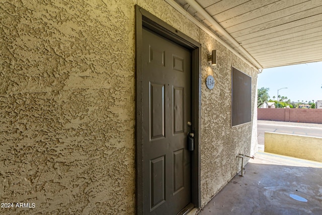 property entrance featuring fence and stucco siding