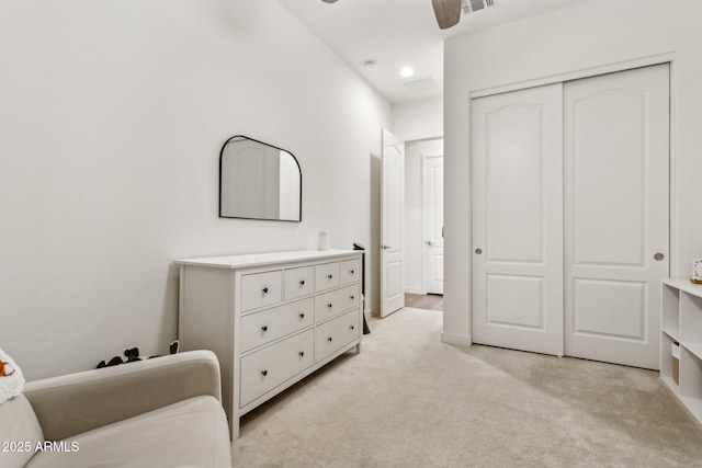 bedroom featuring light carpet, visible vents, a closet, and a ceiling fan