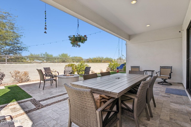 view of patio featuring an outdoor fire pit, outdoor dining area, and fence